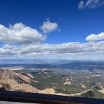 alt="tops of trees, sky clouds from van window as we drive up the mountain"