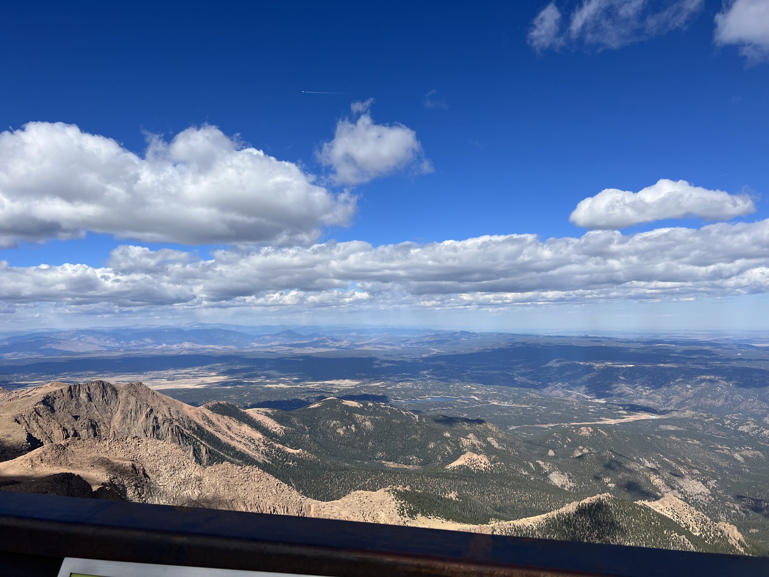 alt="tops of trees, sky clouds from van window as we drive up the mountain"
