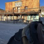 alt="old style wooden building with donkeys outside"
