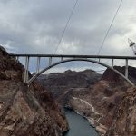 alt="the bridge across the dam with electric pylons in background"