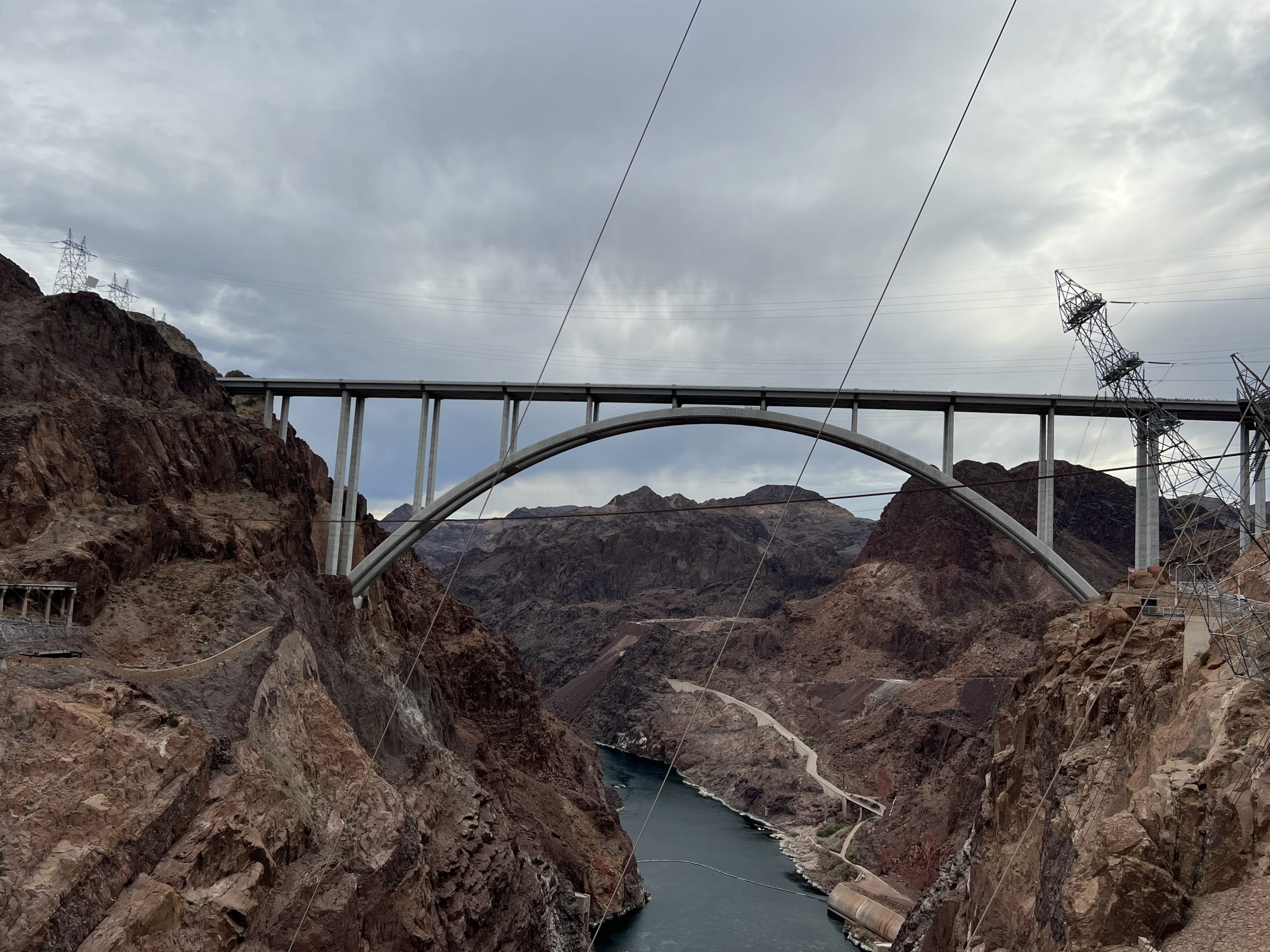 alt="the bridge across the dam with electric pylons in background"