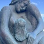 alt="statue of a family holding each other in an embrace"