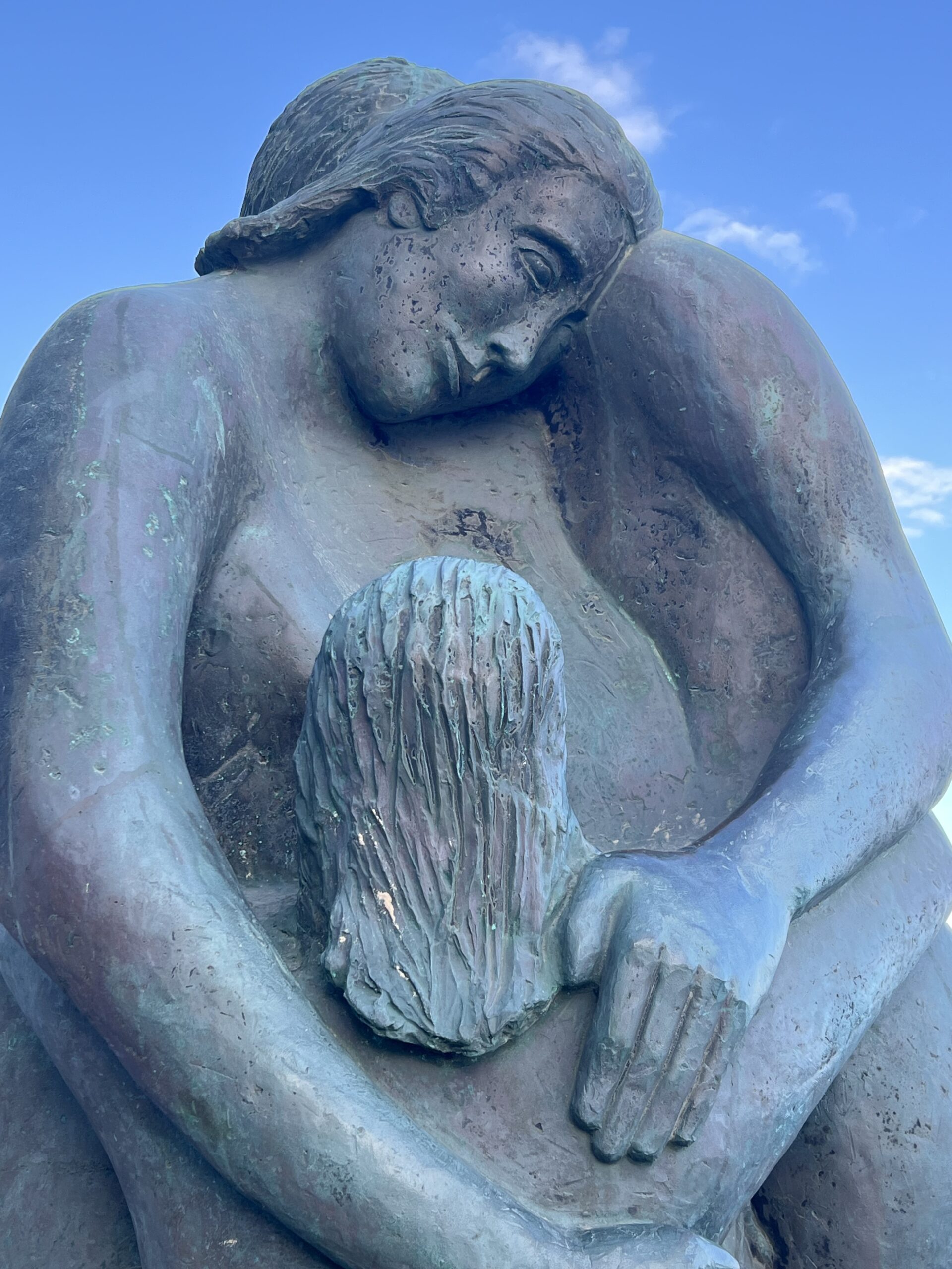 alt="statue of a family holding each other in an embrace"