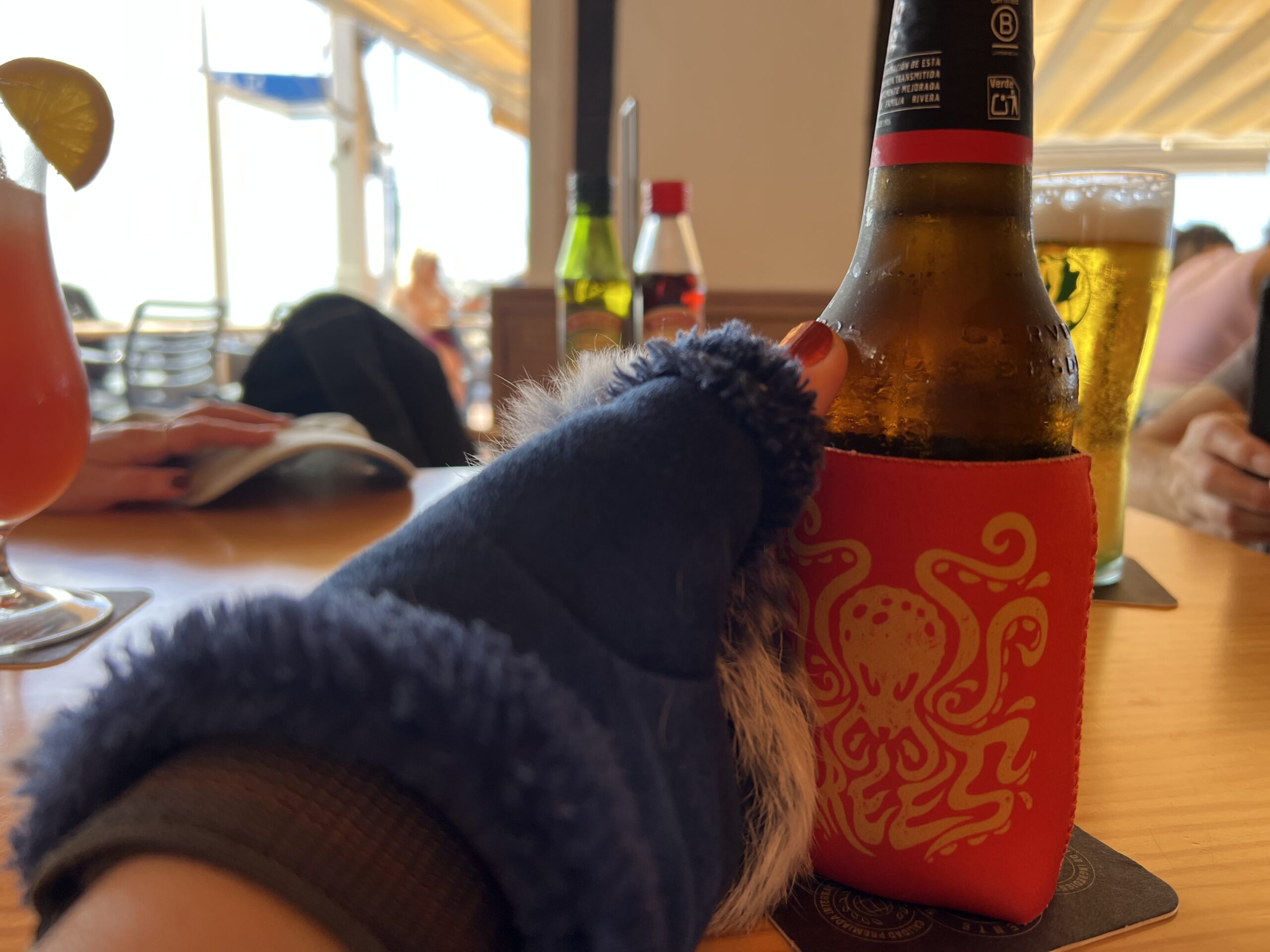 " my gloved hand reaching out to pick up a bottle of beer in insulated sleeve"