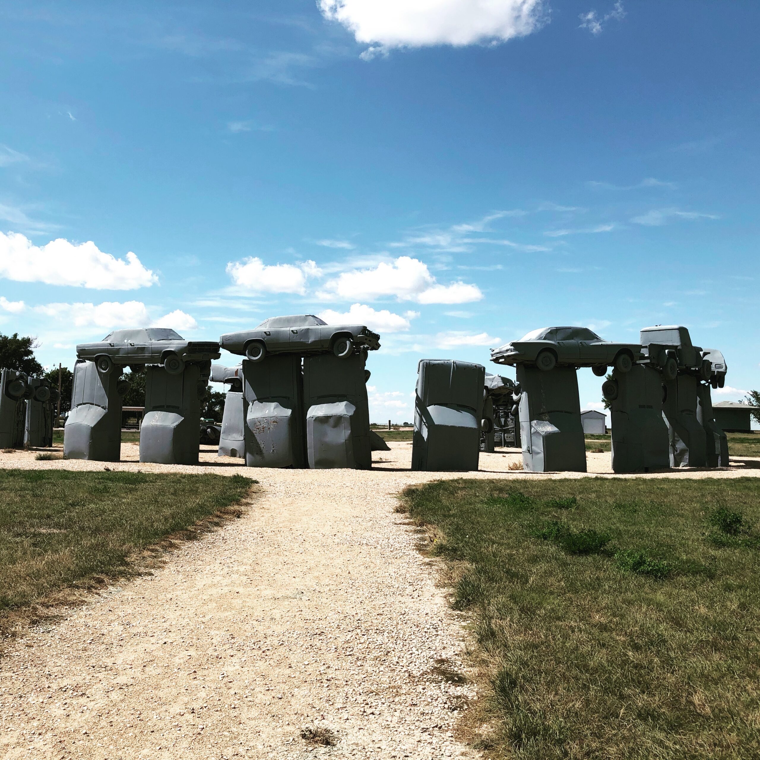 alt="old cars placed like stone henge"