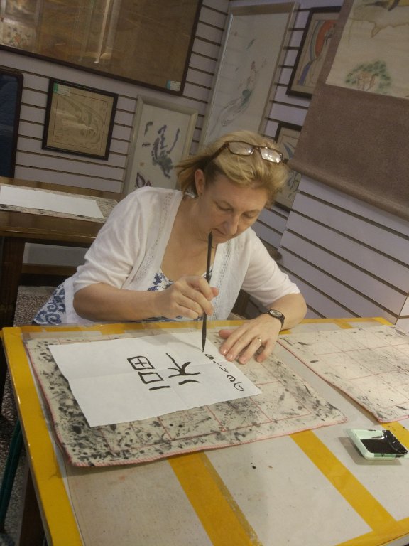 alt="person using brush to write"