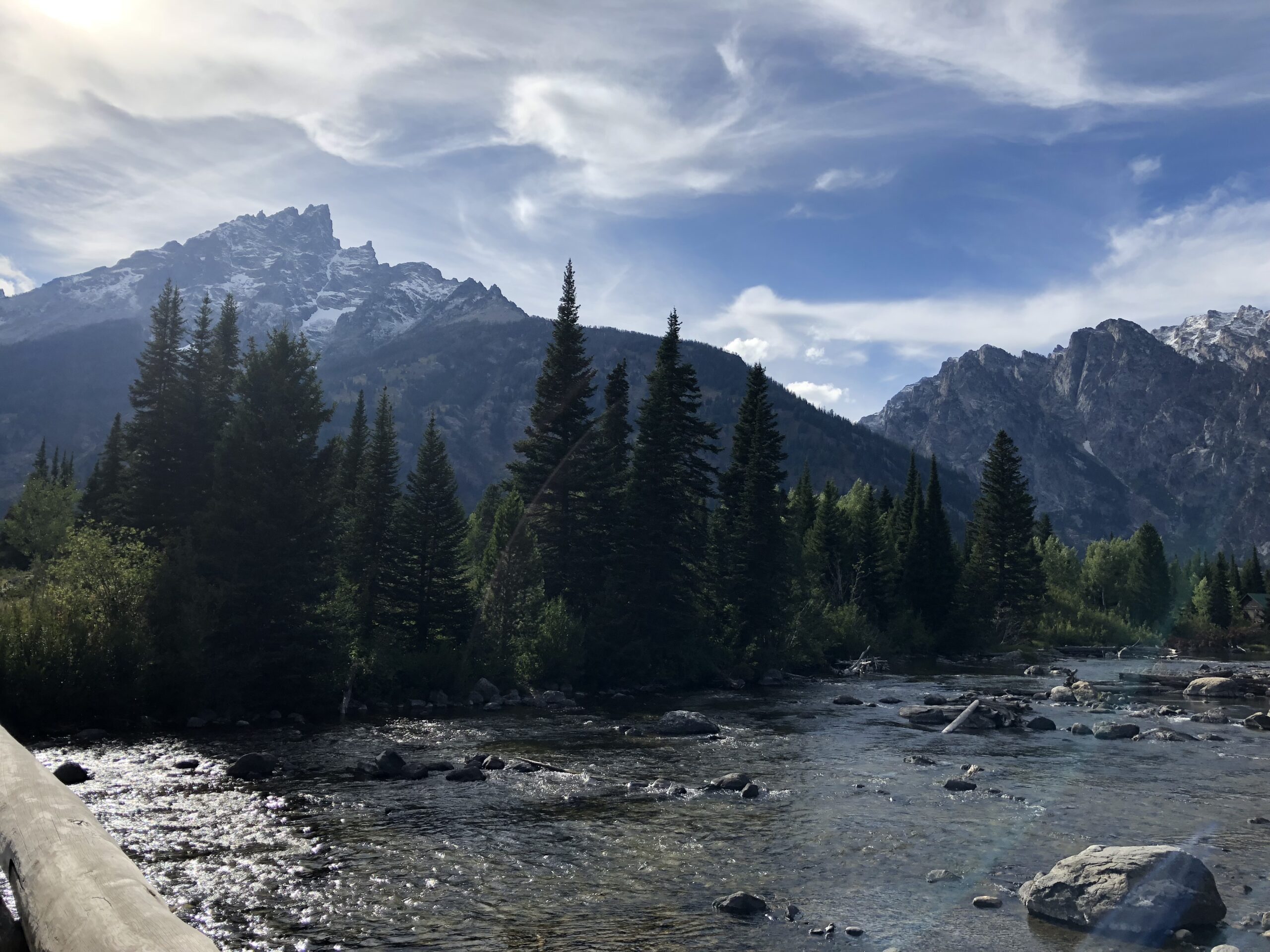 alt="mountains with snow on peaks & river with pine trees"