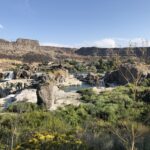 alt="looking across the scrub land from the footpath towards the waterfalls"