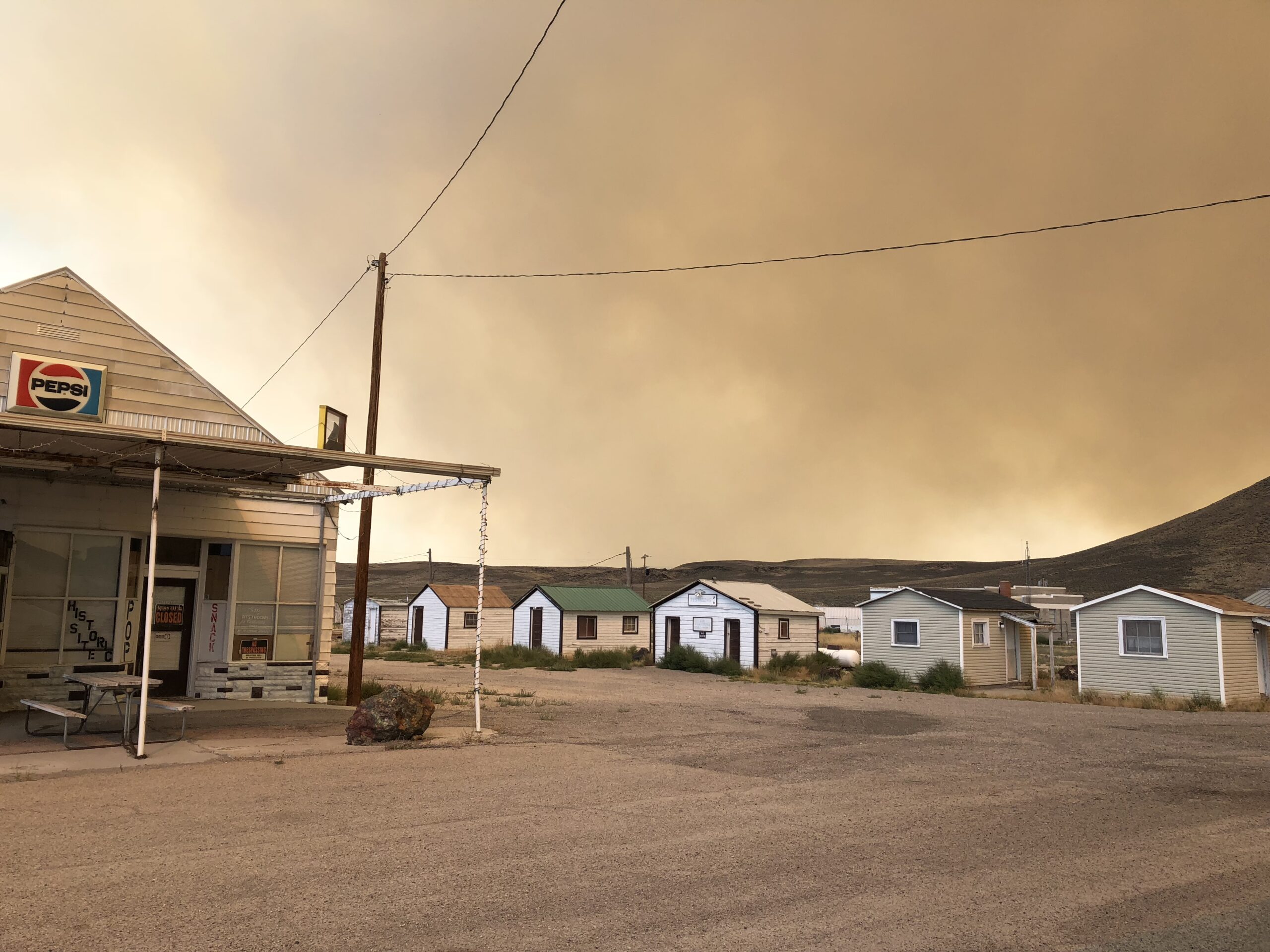alt="smoke filled sky over old buildings"