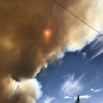 alt="sun trying to shine through huge cloud of smoke"