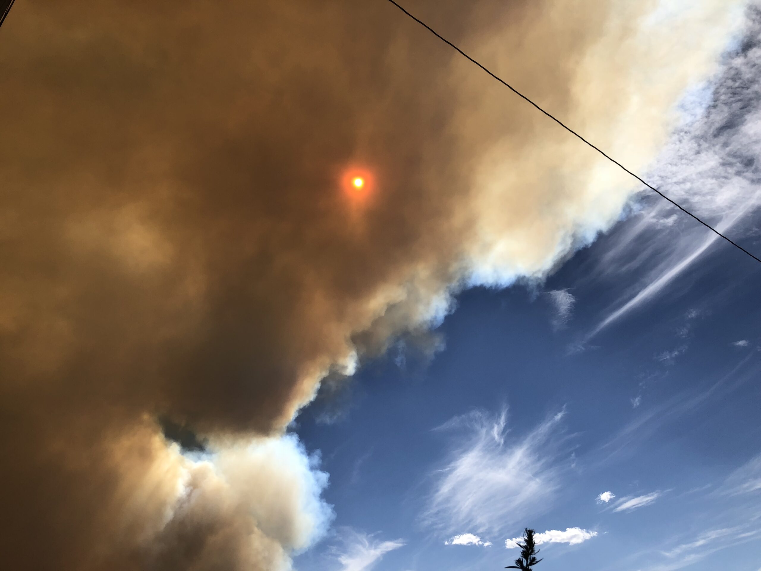 alt="sun trying to shine through huge cloud of smoke"