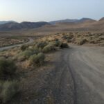 alt="rough track with mountains on background"