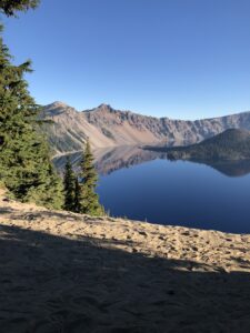 alt="lake and mountain with pine tree in foreground"