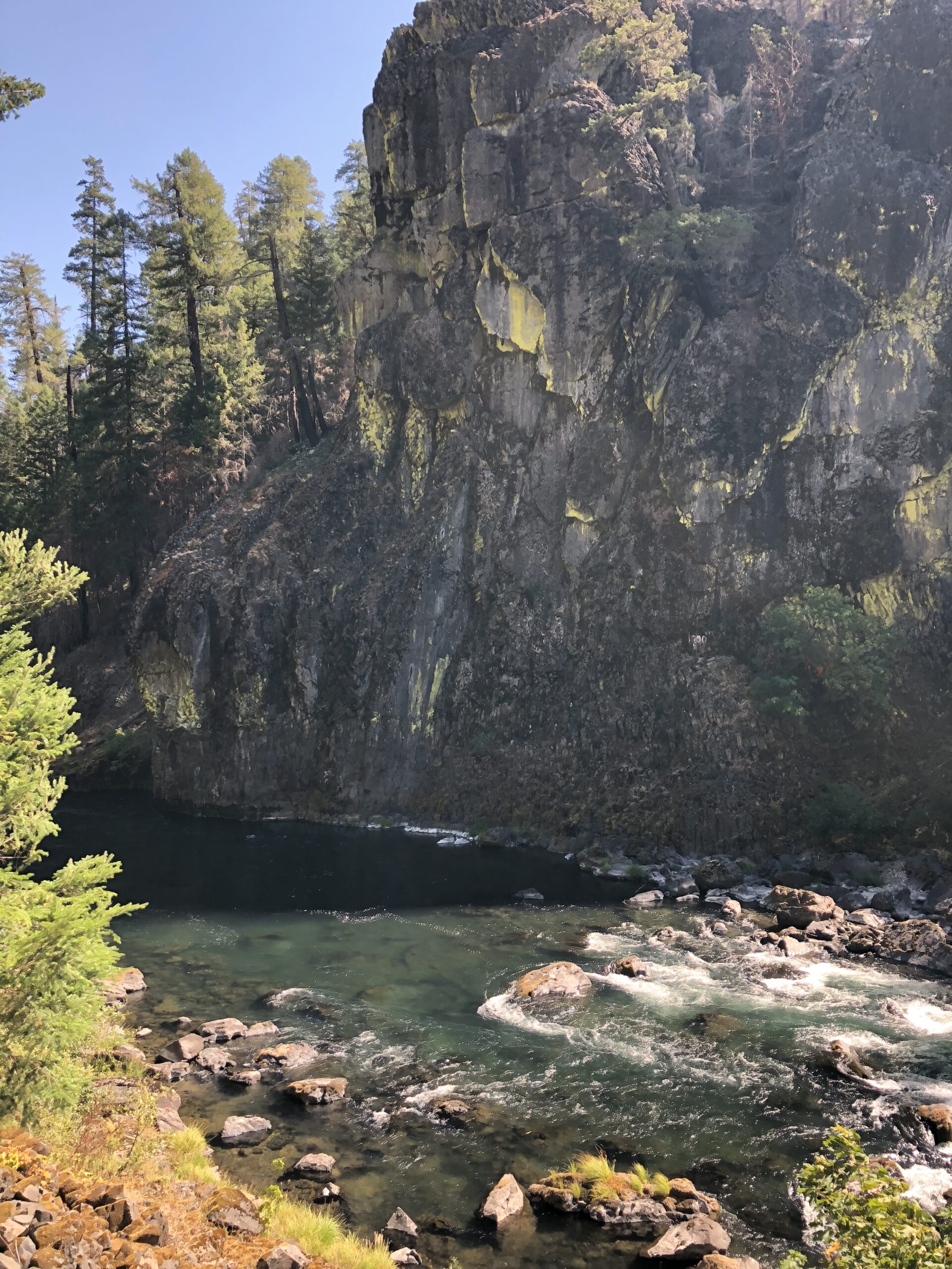 alt=rugged rock outcrop with river below"