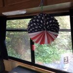 alt=a"paper decoration with the american flag hanging in RV window"