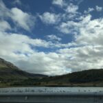 alt=lake with mountain in background & cloudy sky"