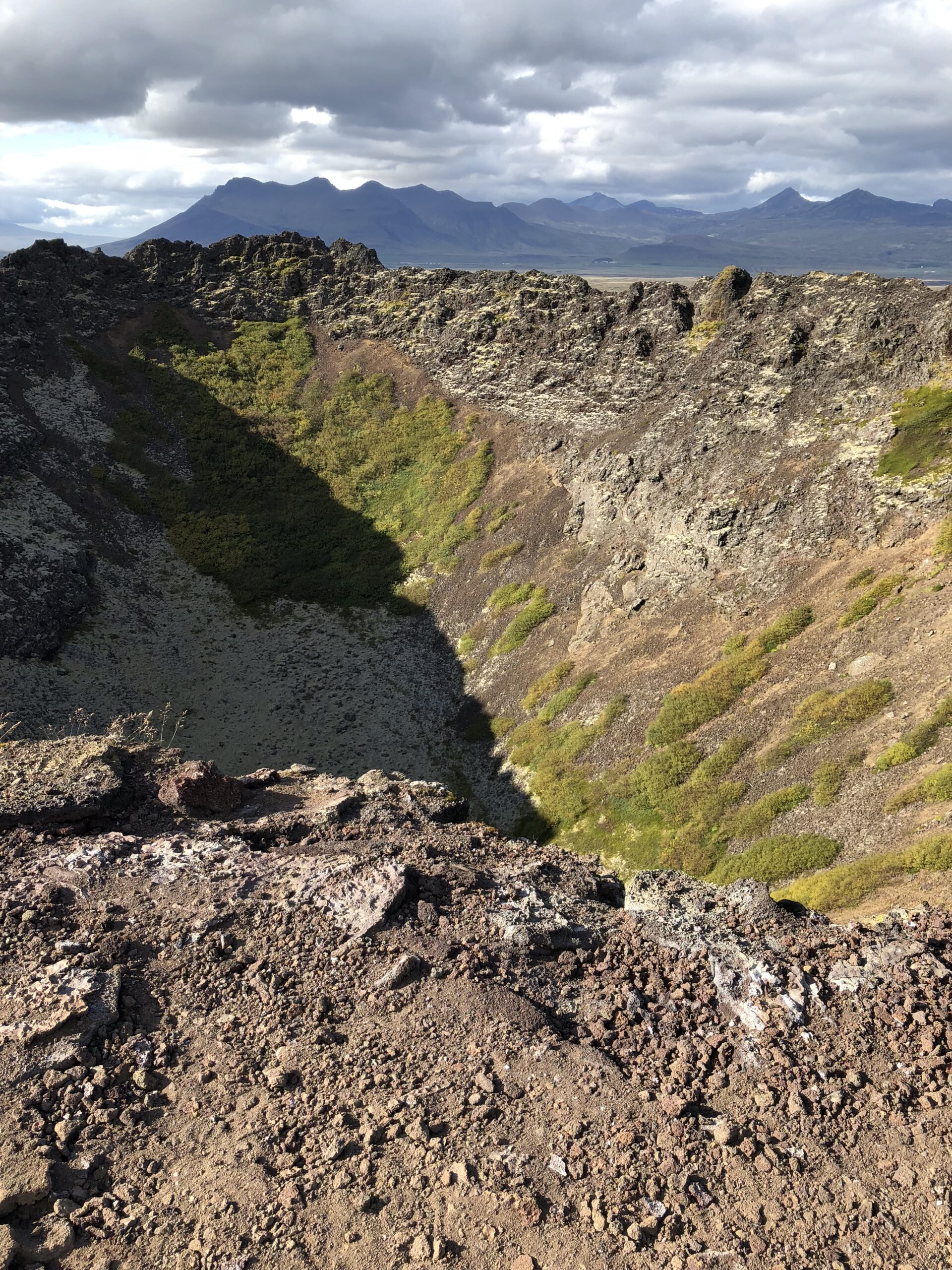 alt="edge of a crater looking down to the bottom"
