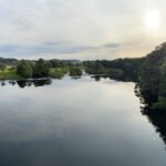 alt="wide expanse of water with trees either side"