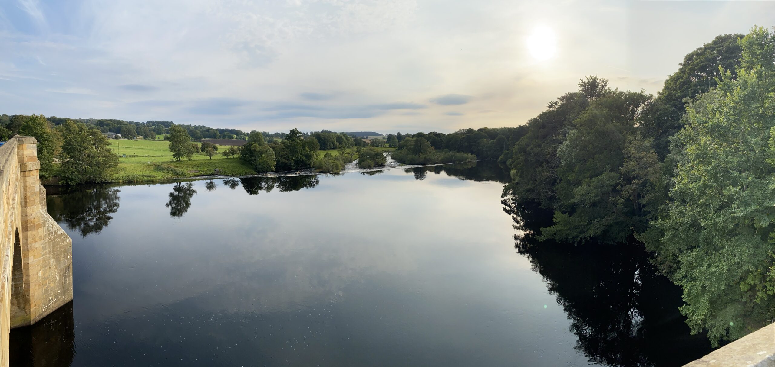 alt="wide expanse of water with trees either side"
