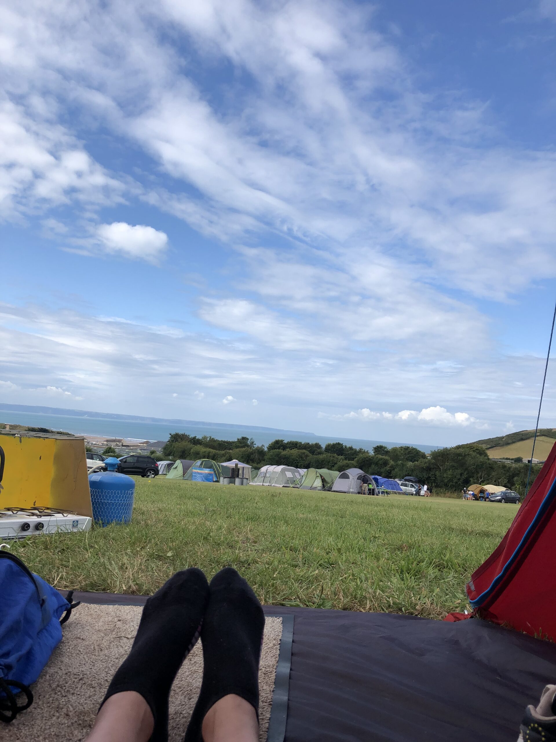 alt="tents with sea & sky"