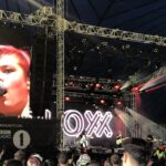 alt="band on stage with crowd in front"