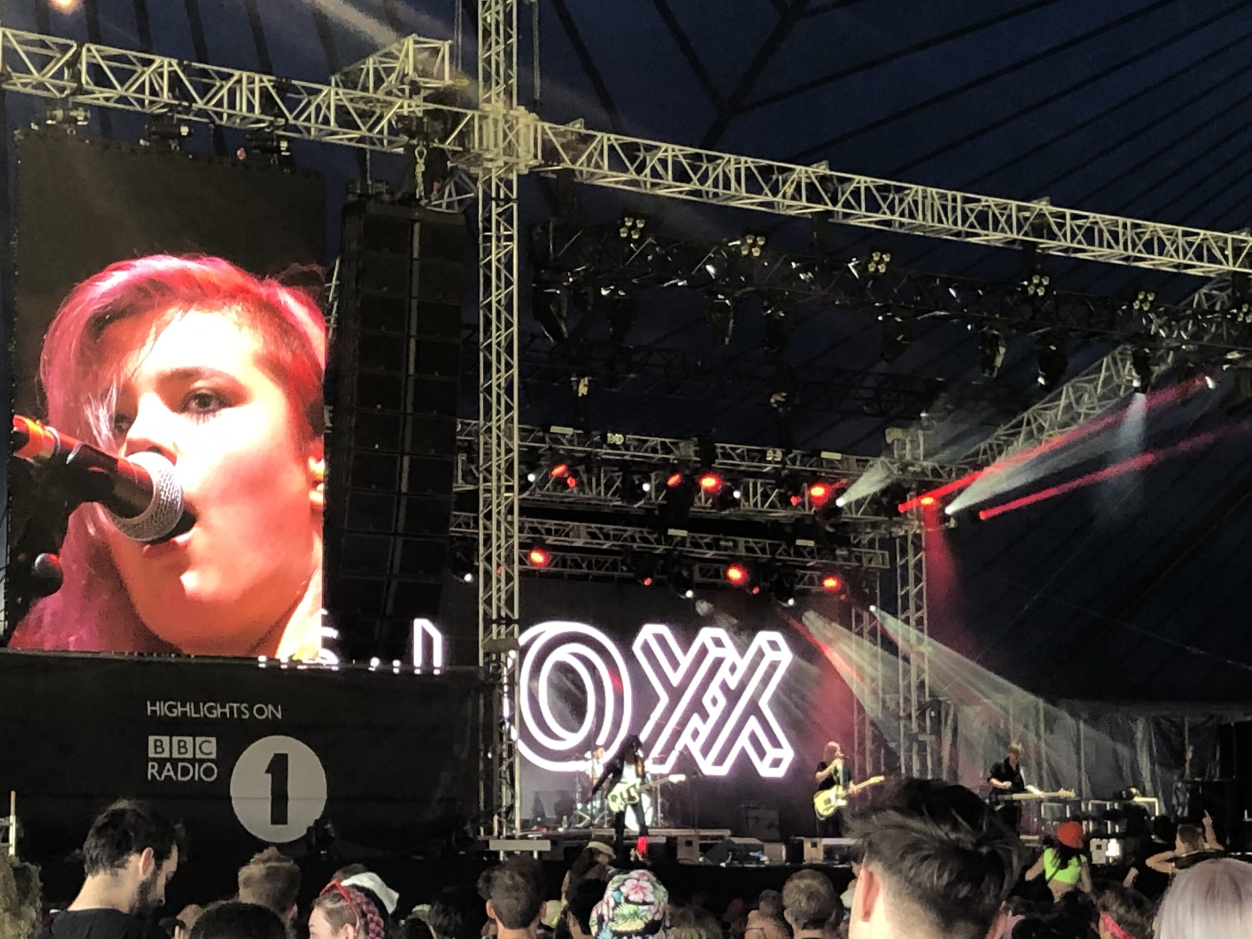 alt="band on stage with crowd in front"