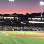 alt="floodlit baseball field with players"
