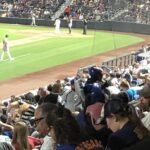 alt="baseball players in corner of field"