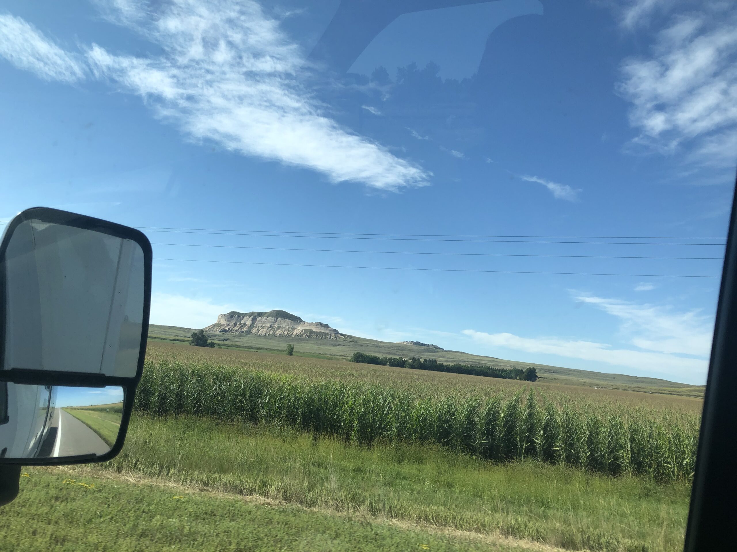 alt="crop in foreground with rock outcrop in distance"