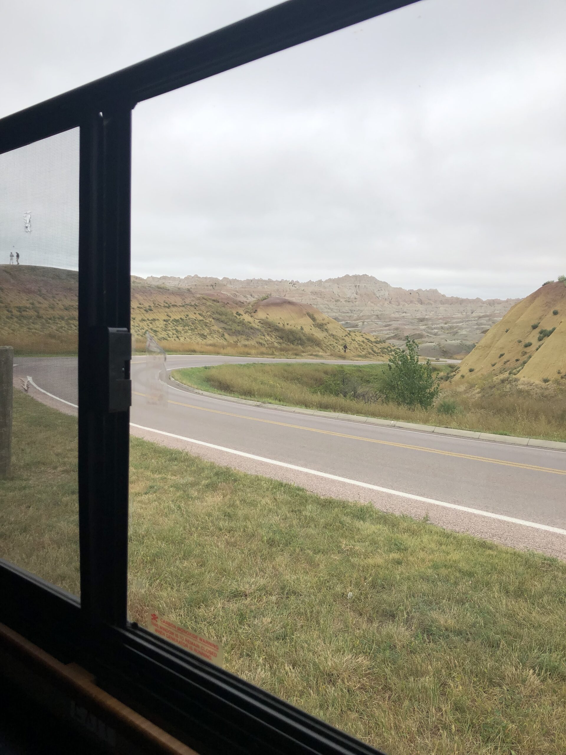 al="curve in road with badlands in background"