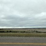 alt="road with grass & rocks in distance"