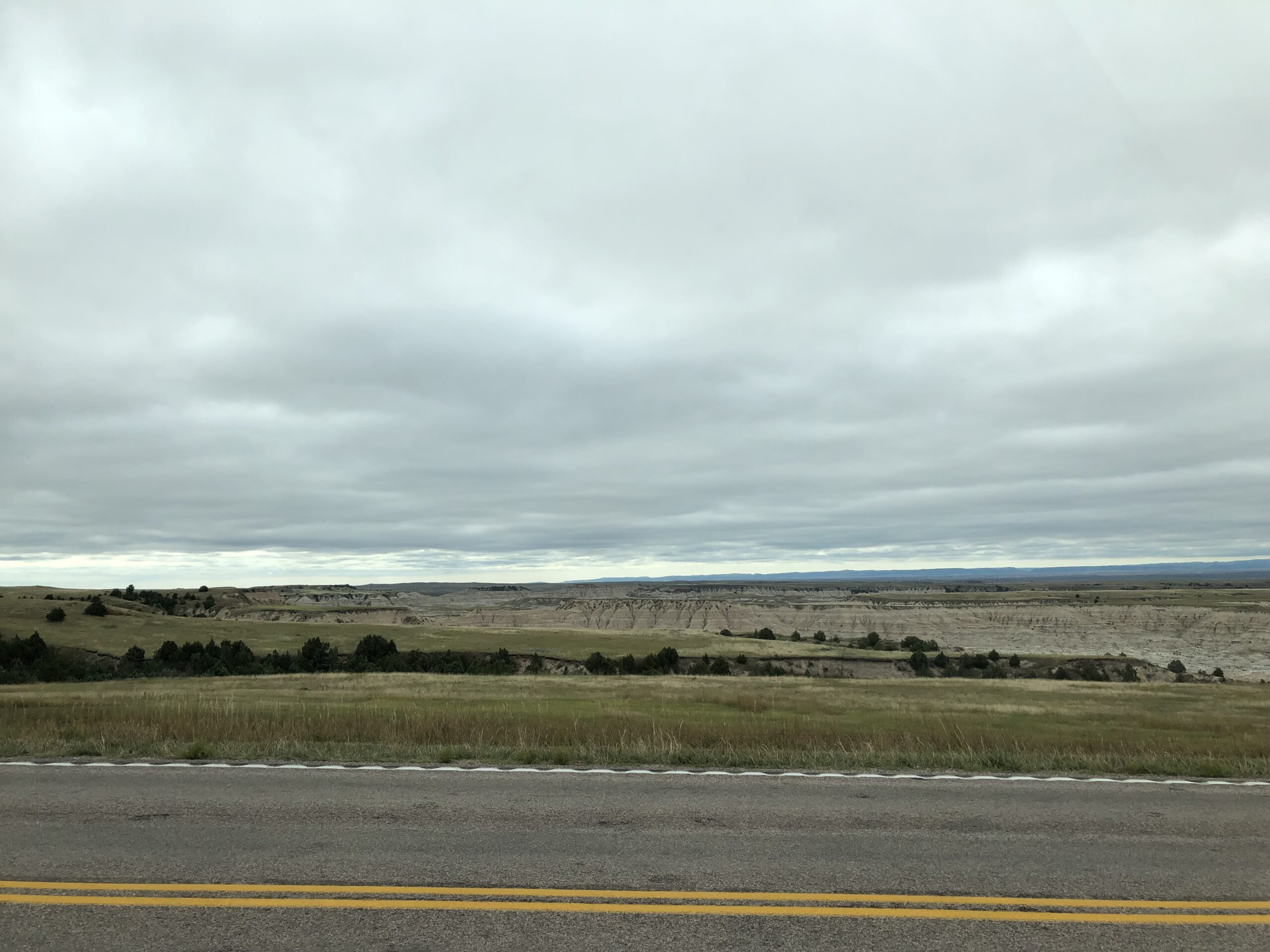 alt="road with grass & rocks in distance"