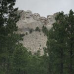 alt="trees with stone faces above"