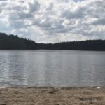 alt=sandy bank with lake & trees"