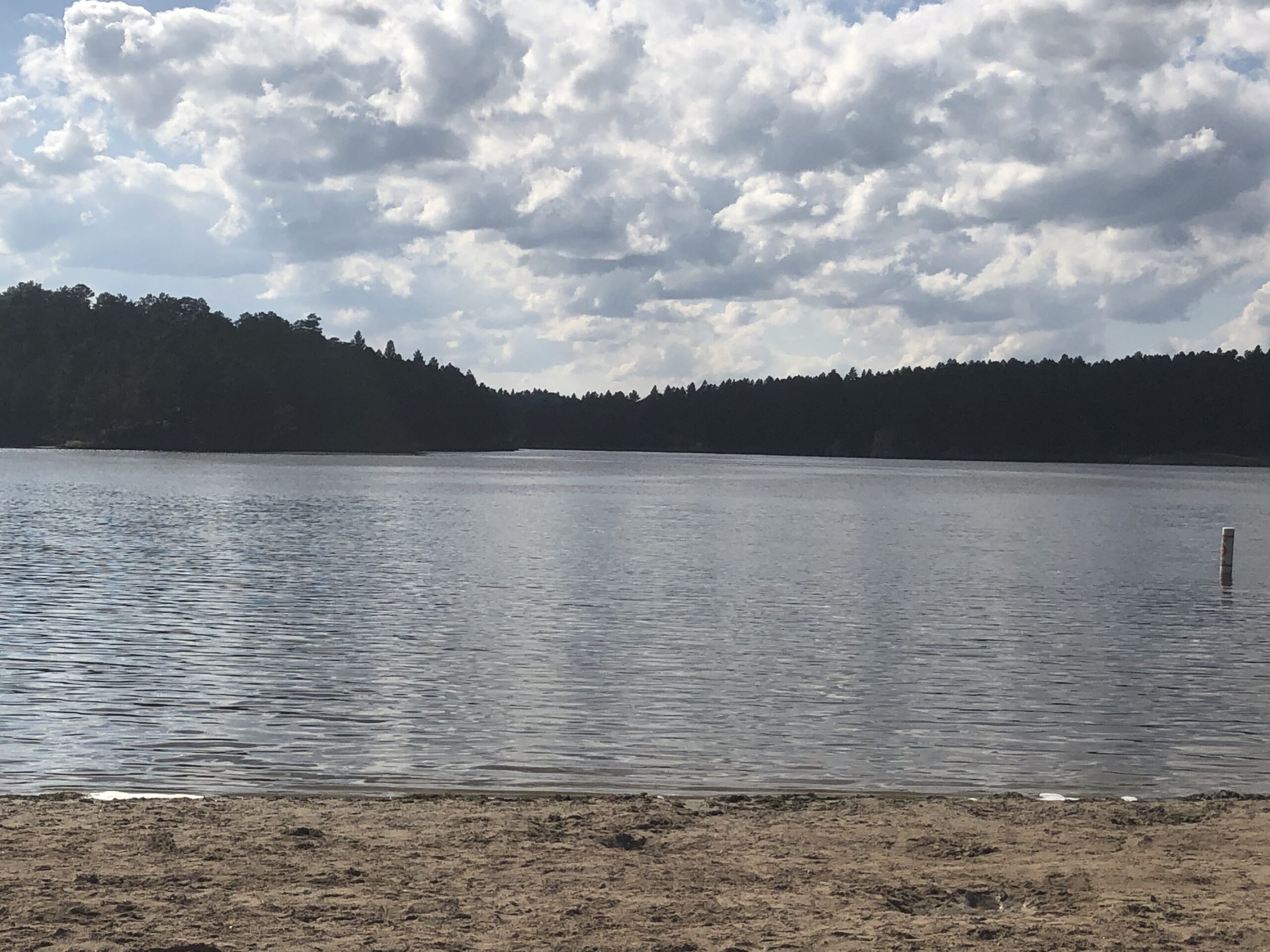 alt=sandy bank with lake & trees"