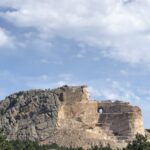 alt="rock outcrop with carving of face"