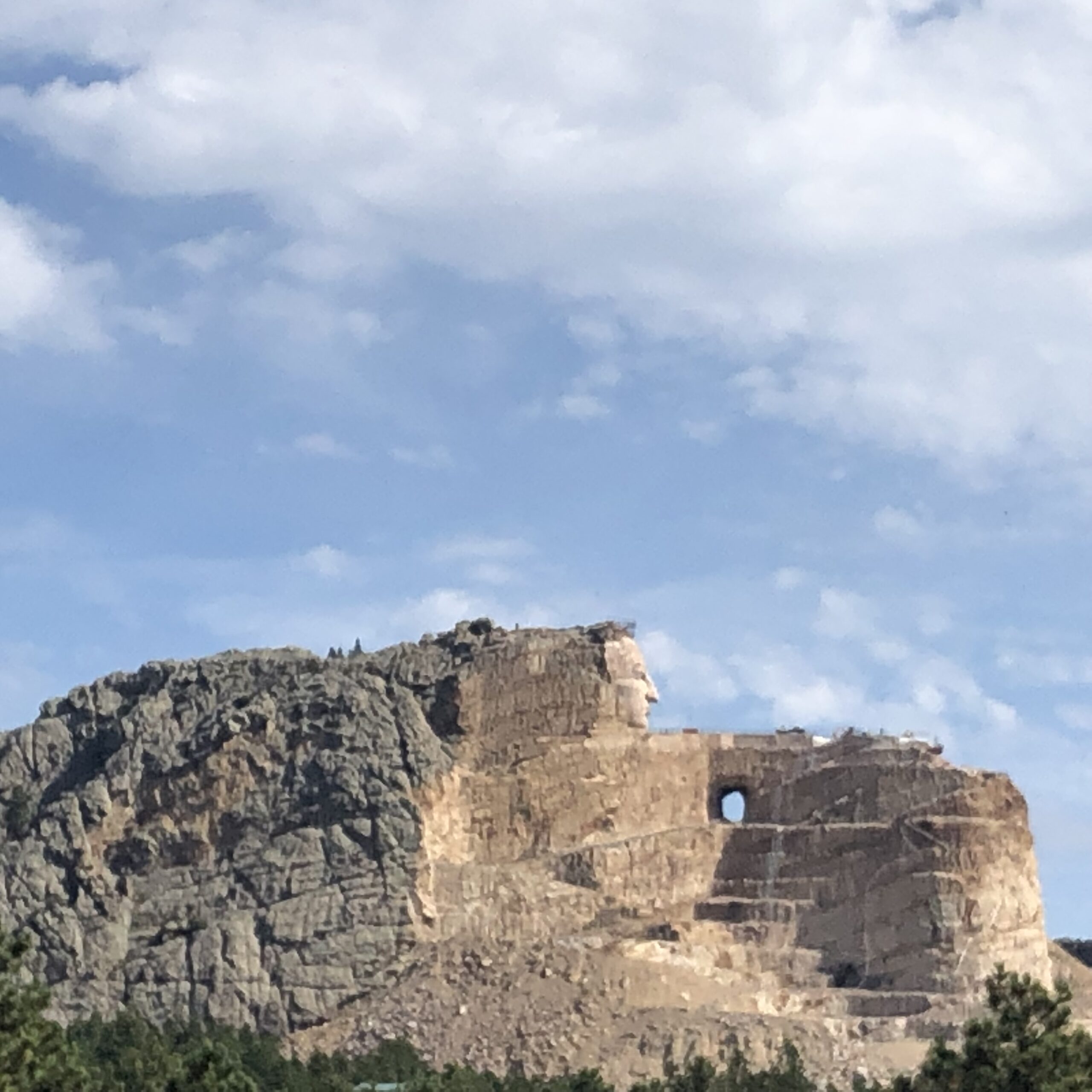 alt="rock outcrop with carving of face"