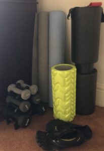 alt="foam rollers of different shapes & sizes plus hand weights"