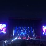 alt="images on screens either side of main stage"