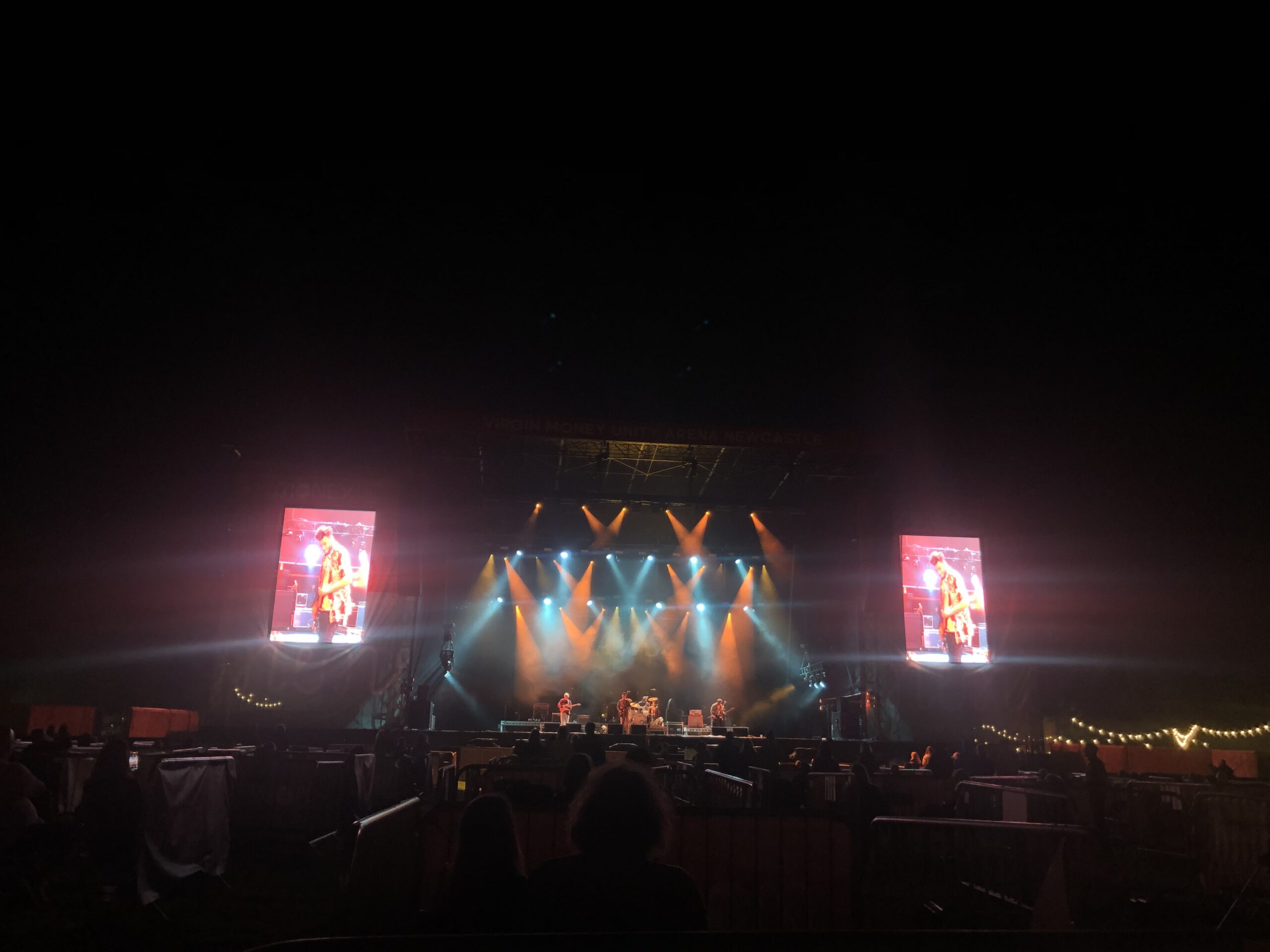 alt="main stage at night lit with coloured lights"