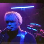 alt="person singing into microphone"