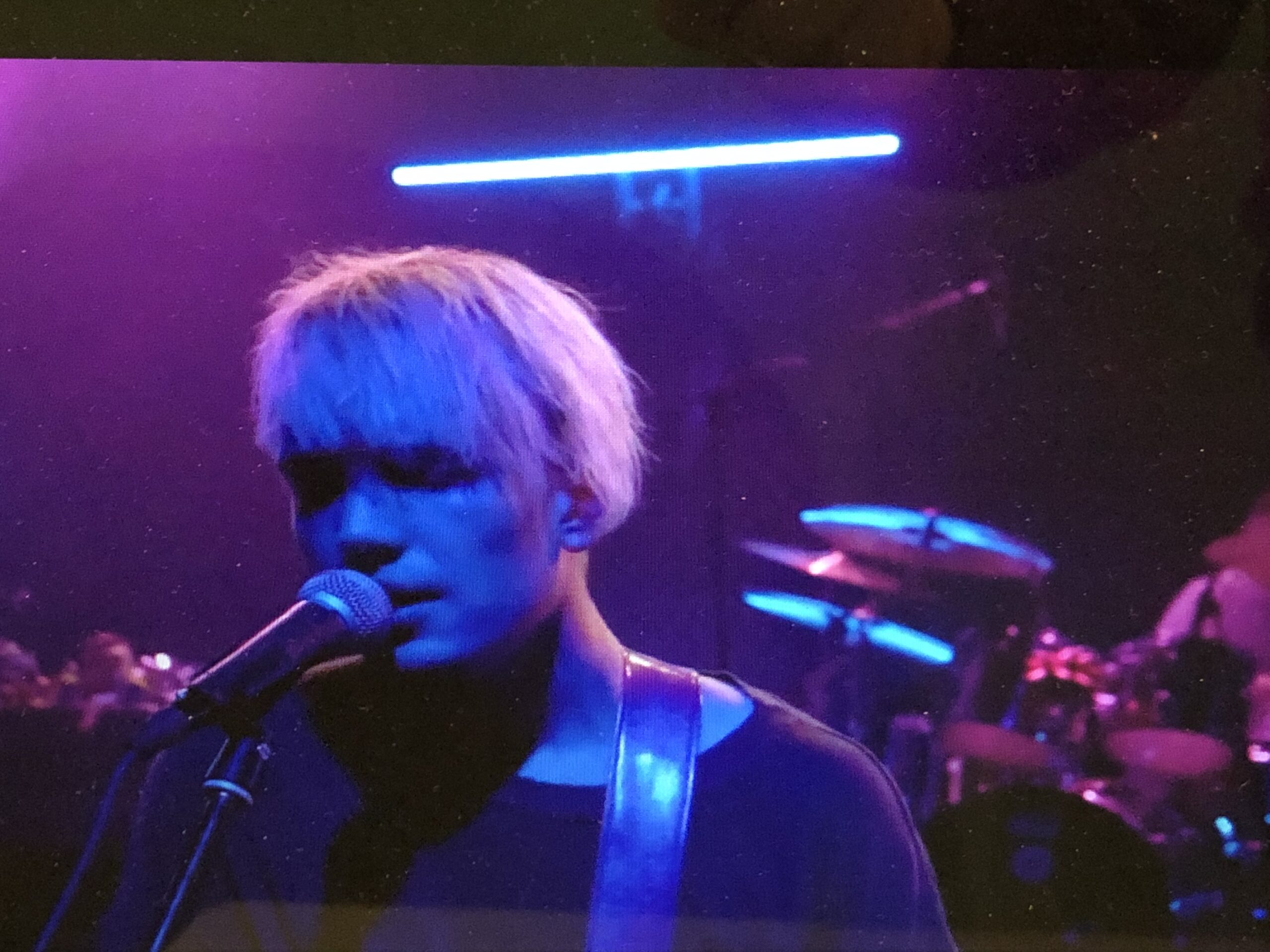 alt="person singing into microphone"