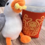alt="toy seagull next to a glass"