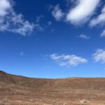 alt="edge of crater with sky above"