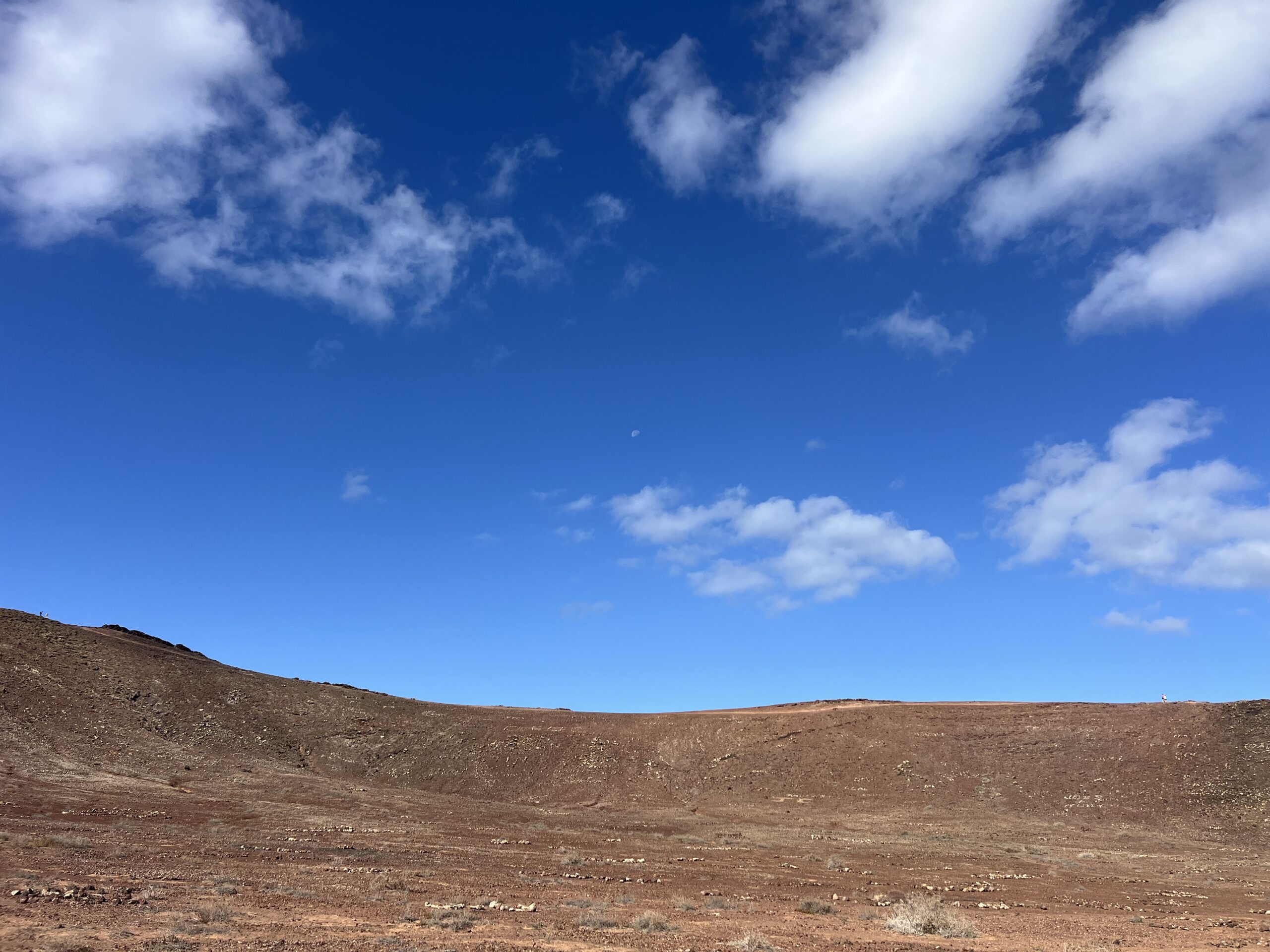 alt="edge of crater with sky above"