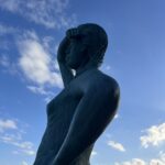 alt="figure looking to sea"