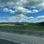 alt="road & barrier with fields & sky"