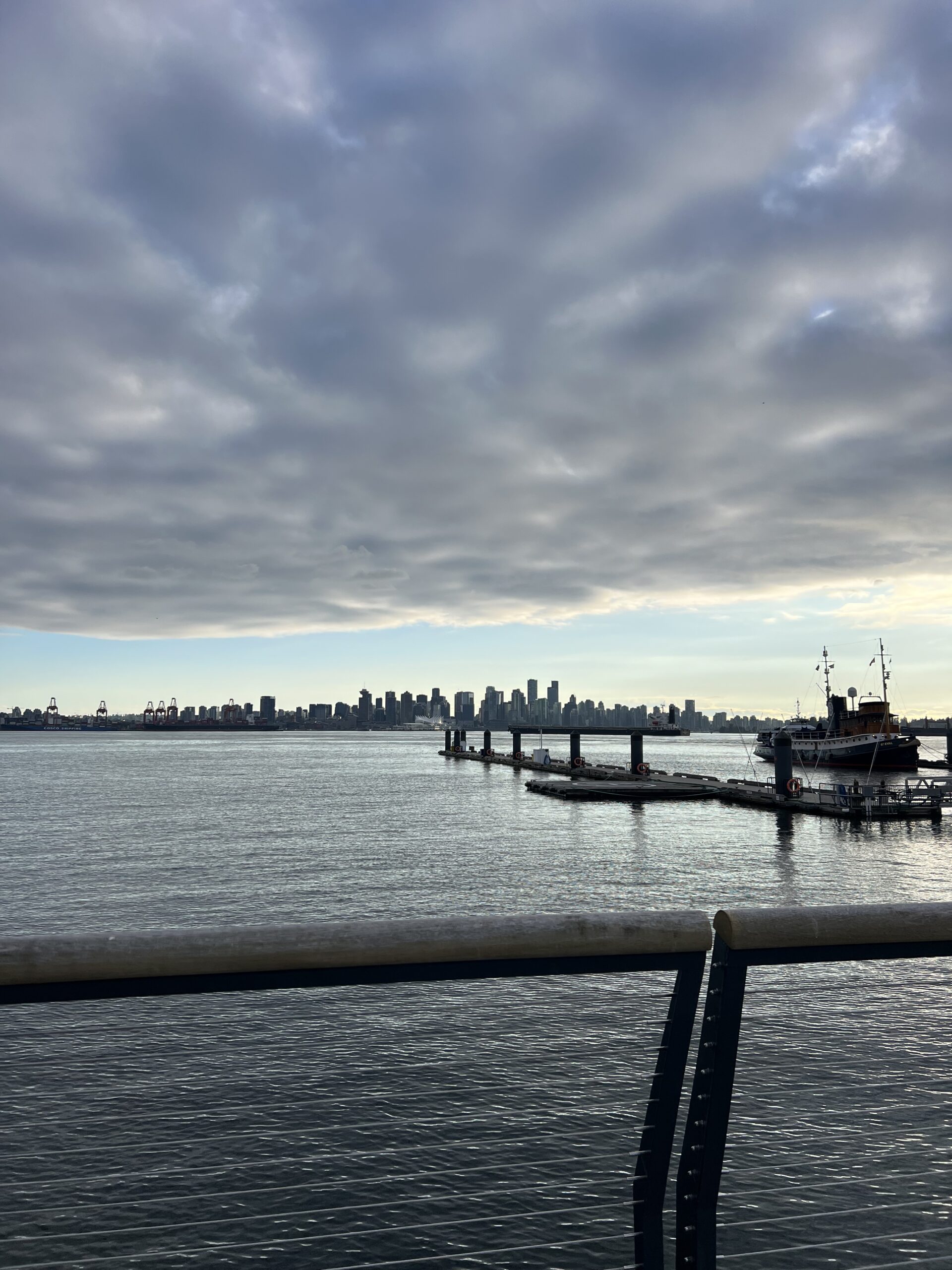alt="water & boat moorings with clouds above"